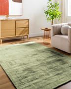 Modern distressed green wool rug with abstract texture and mottled pattern