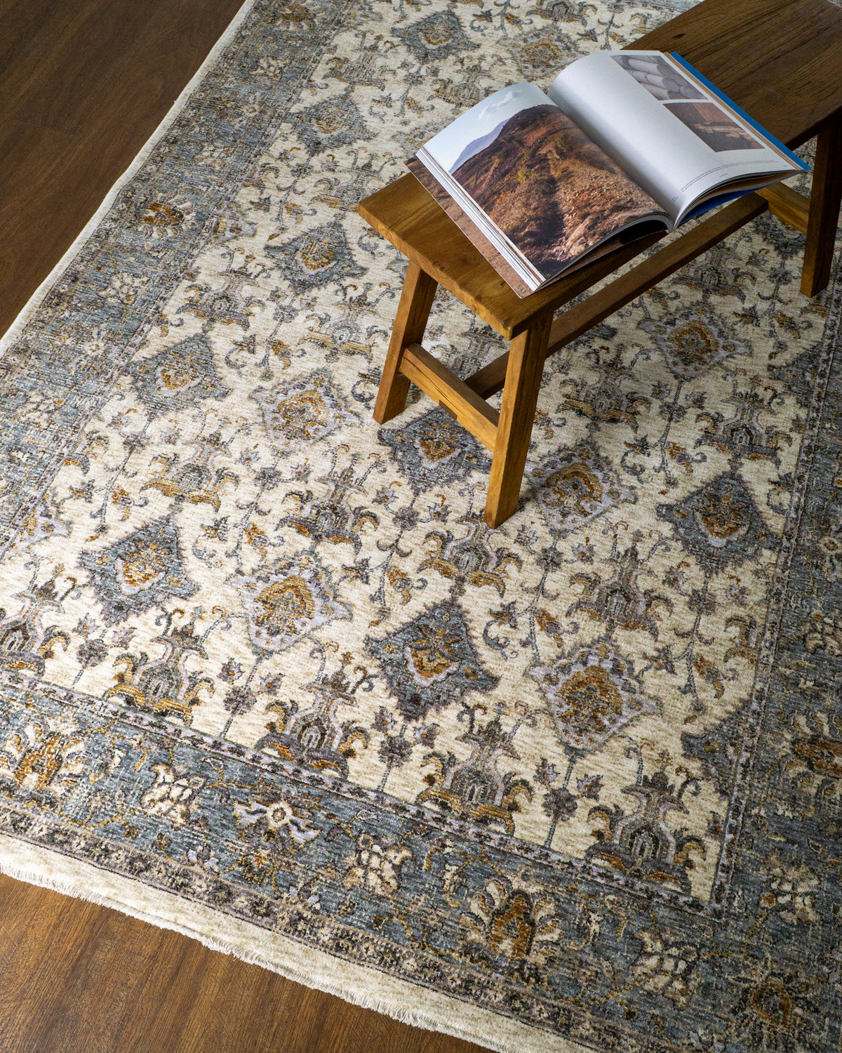 Cream and blue traditional rug with geometric diamond patterns and ornate border