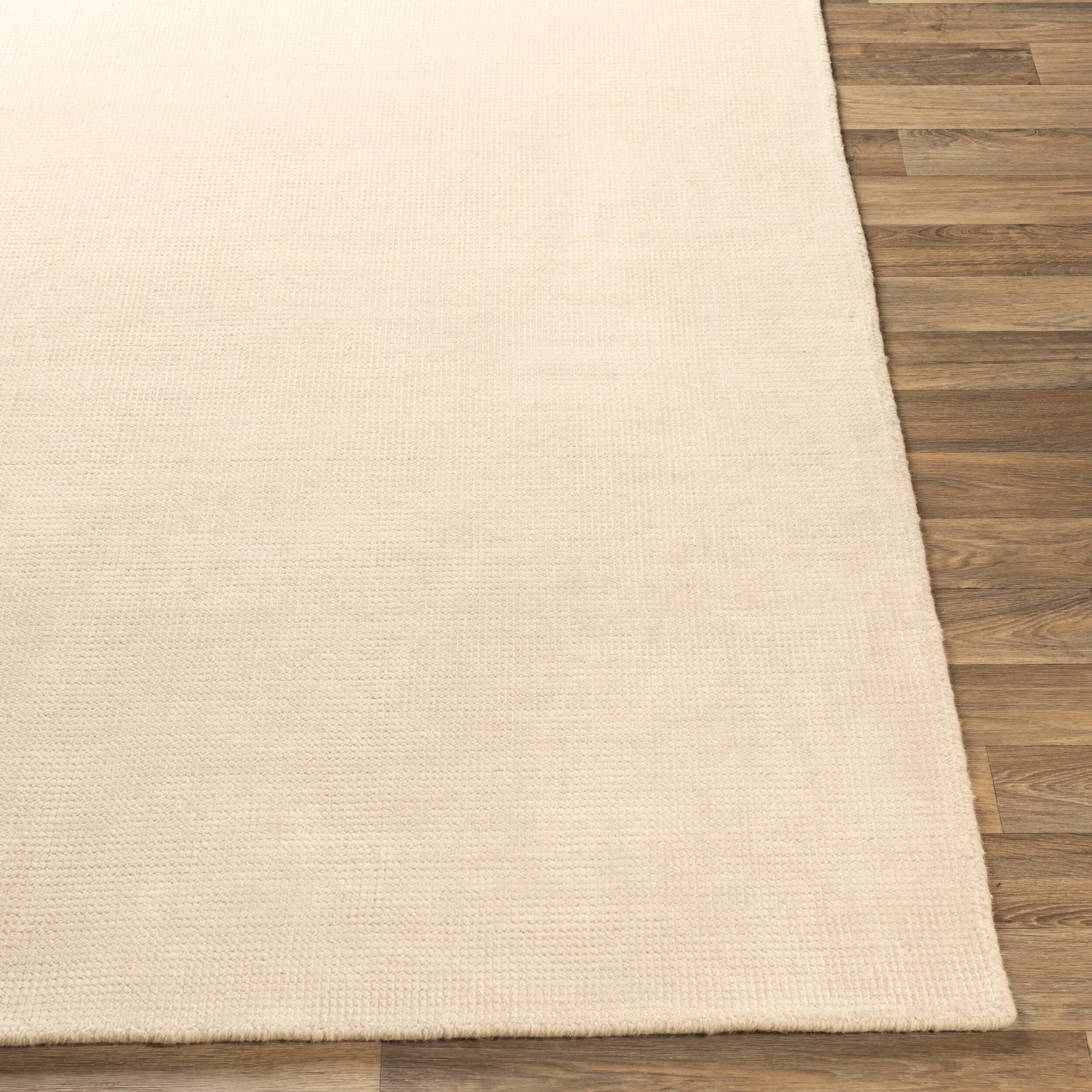 Cream colored wool rug with subtle woven texture and natural fibers