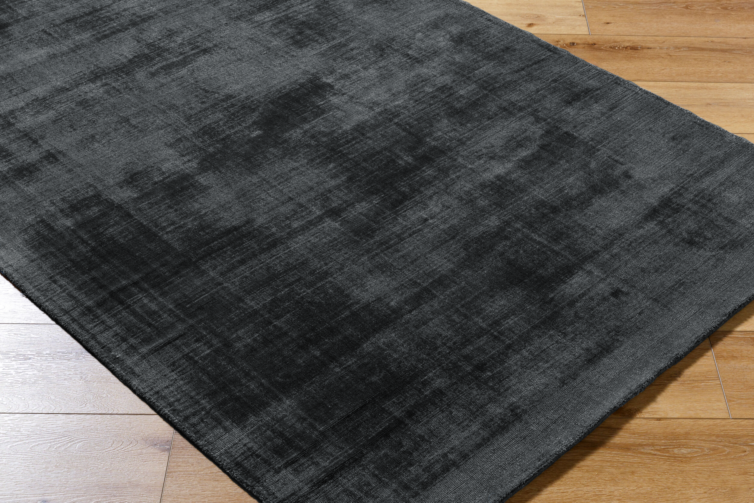 Dark grey distressed wool rug with subtle texture and mottled finish