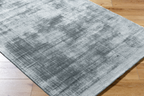 Light blue textured area rug with subtle grey distressed pattern and worn finish