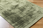 Modern distressed green wool rug with abstract texture and mottled pattern