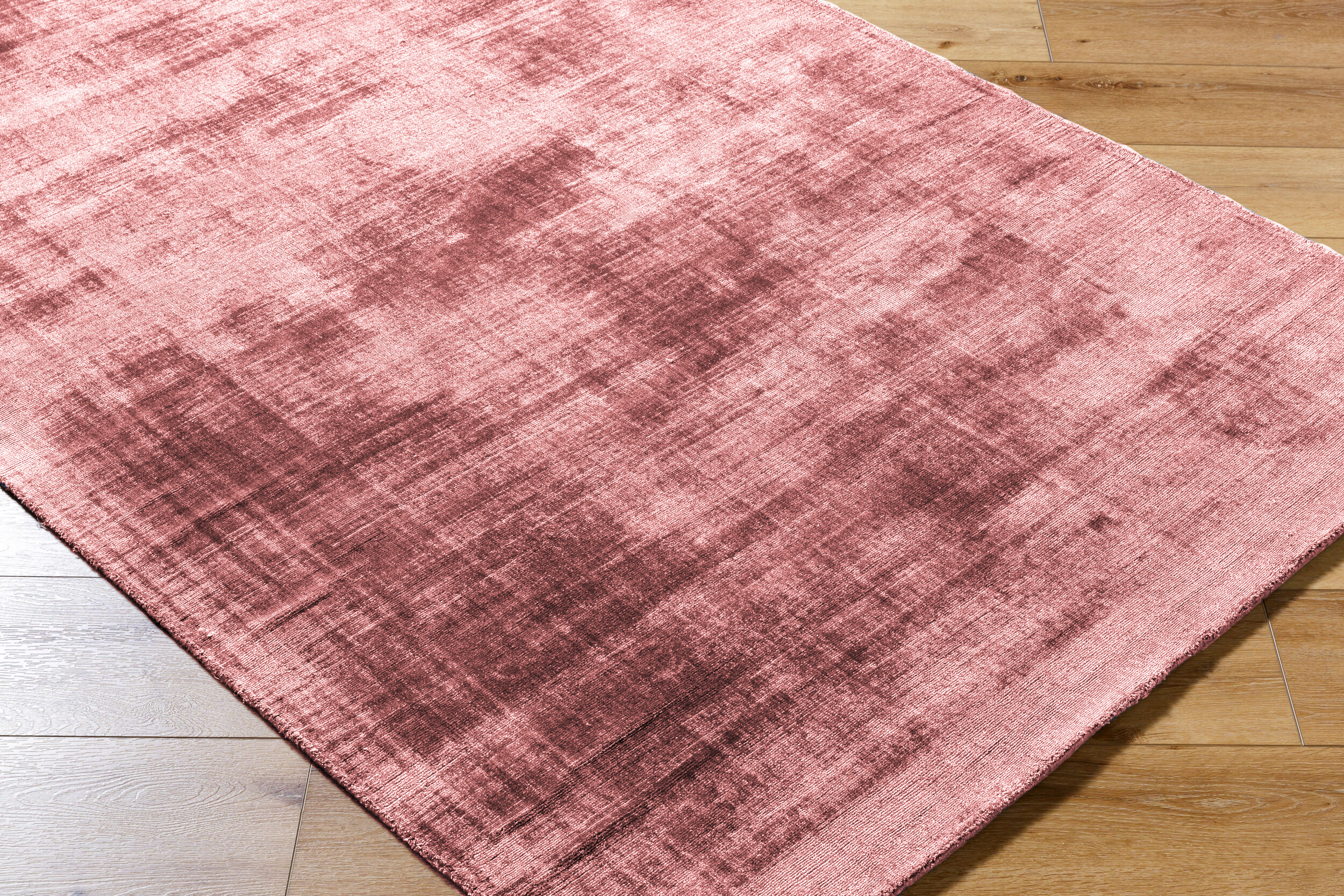 Modern distressed pink area rug with textured abstract pattern