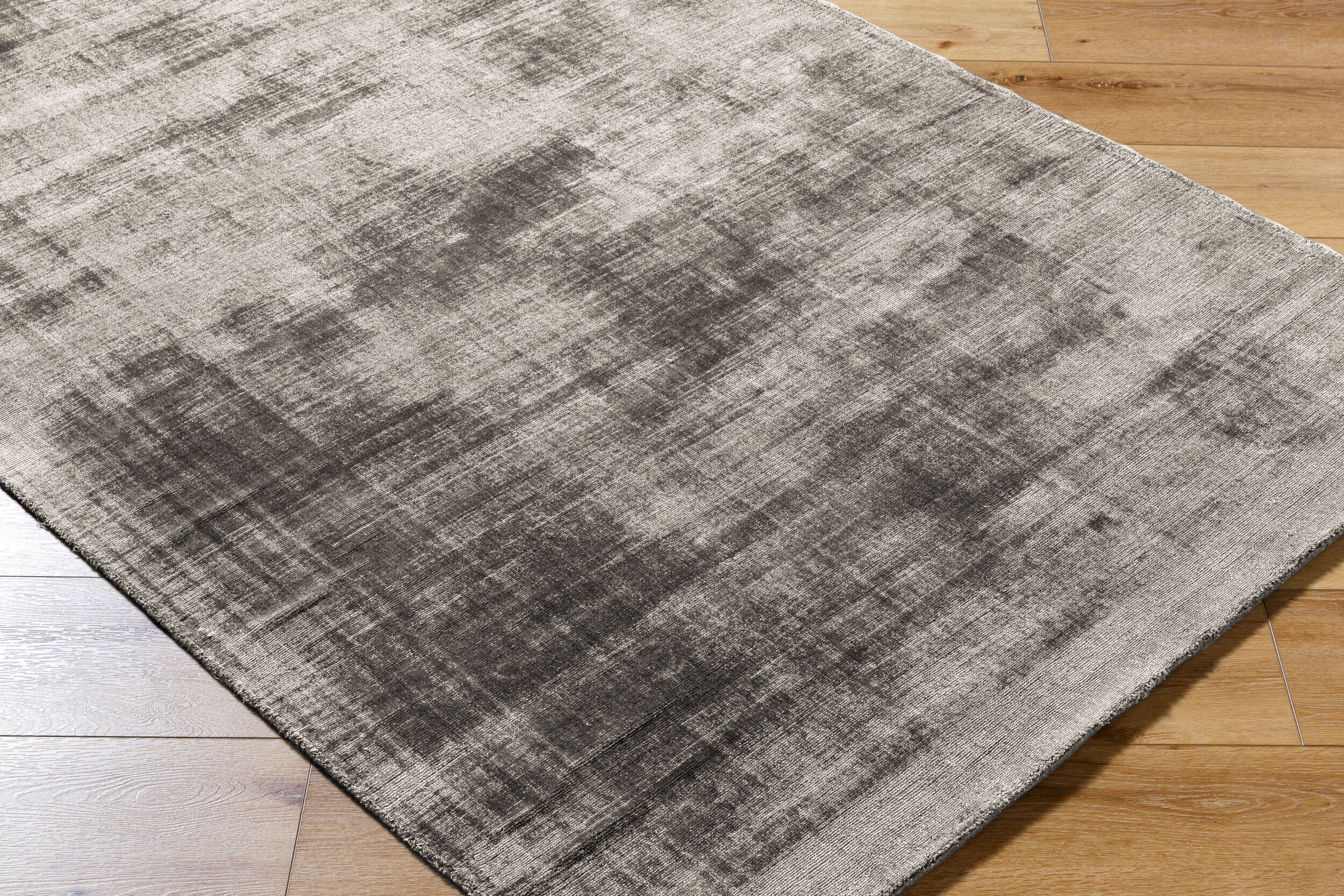 Modern distressed gray area rug with abstract textured pattern and neutral tone