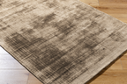 Beige distressed area rug with abstract dark streaks and worn texture throughout