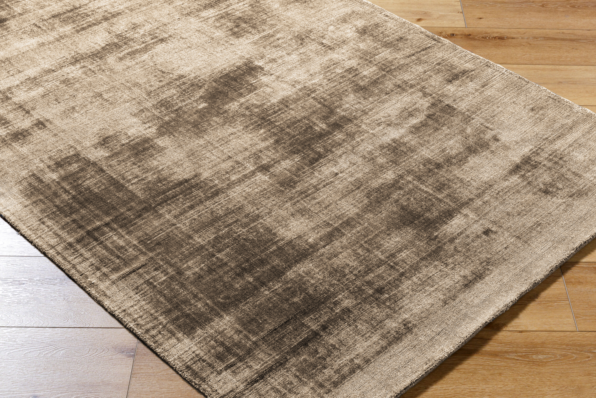 Beige distressed area rug with abstract dark streaks and worn texture throughout