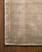 Beige textured rug with subtle horizontal striations and soft woven finish