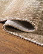 Beige textured rug with subtle horizontal striations and soft woven finish