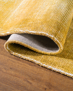 Golden yellow velvet rug with subtle grid texture pattern and worn vintage finish