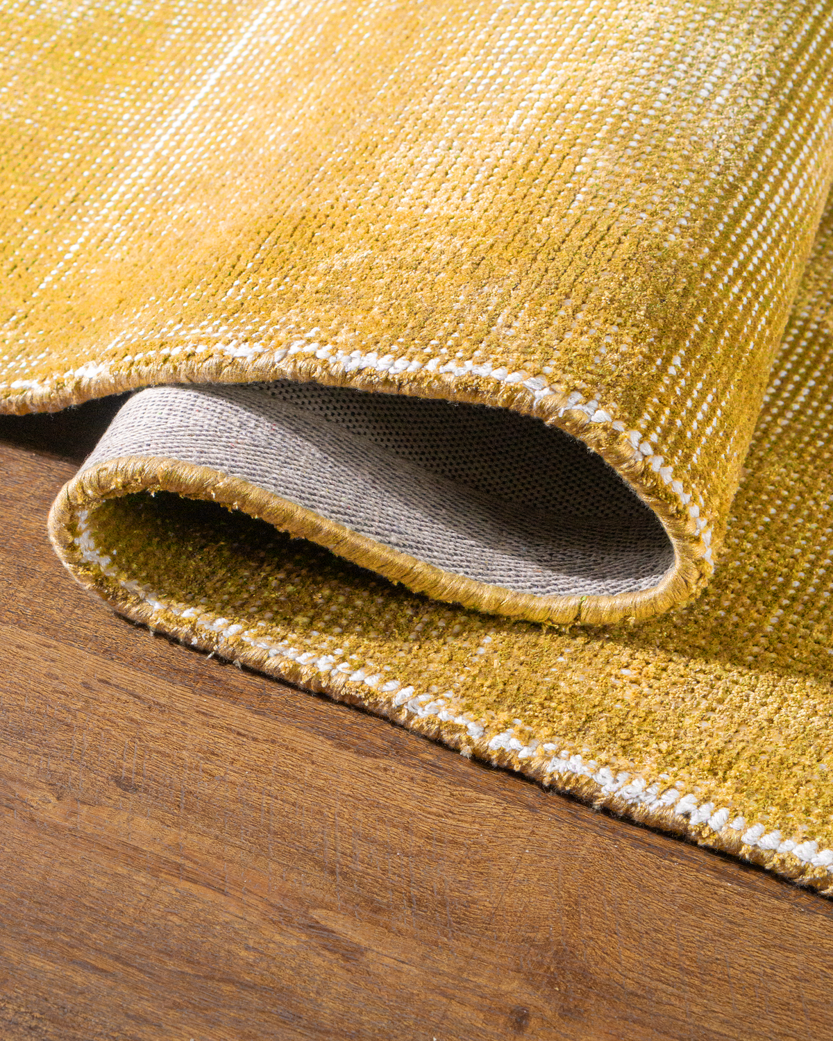Golden yellow velvet rug with subtle grid texture pattern and worn vintage finish