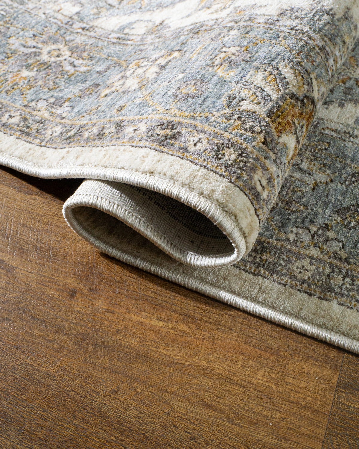 Cream and blue traditional rug with geometric diamond patterns and ornate border