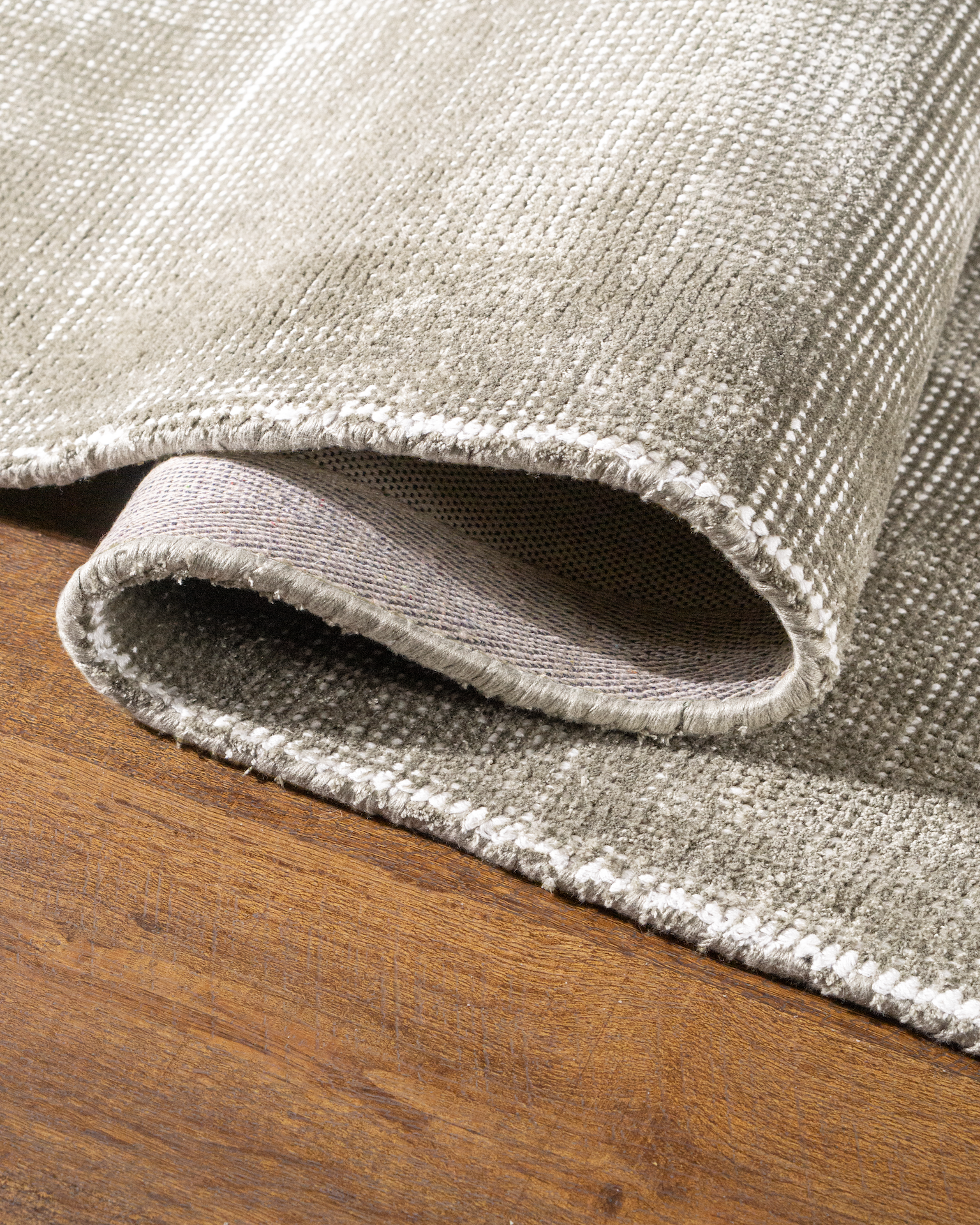 Soft grey velvet rug with subtle texture and neutral tone, rectangular shape