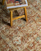 Vintage-style rug with faded terracotta and beige distressed floral pattern throughout
