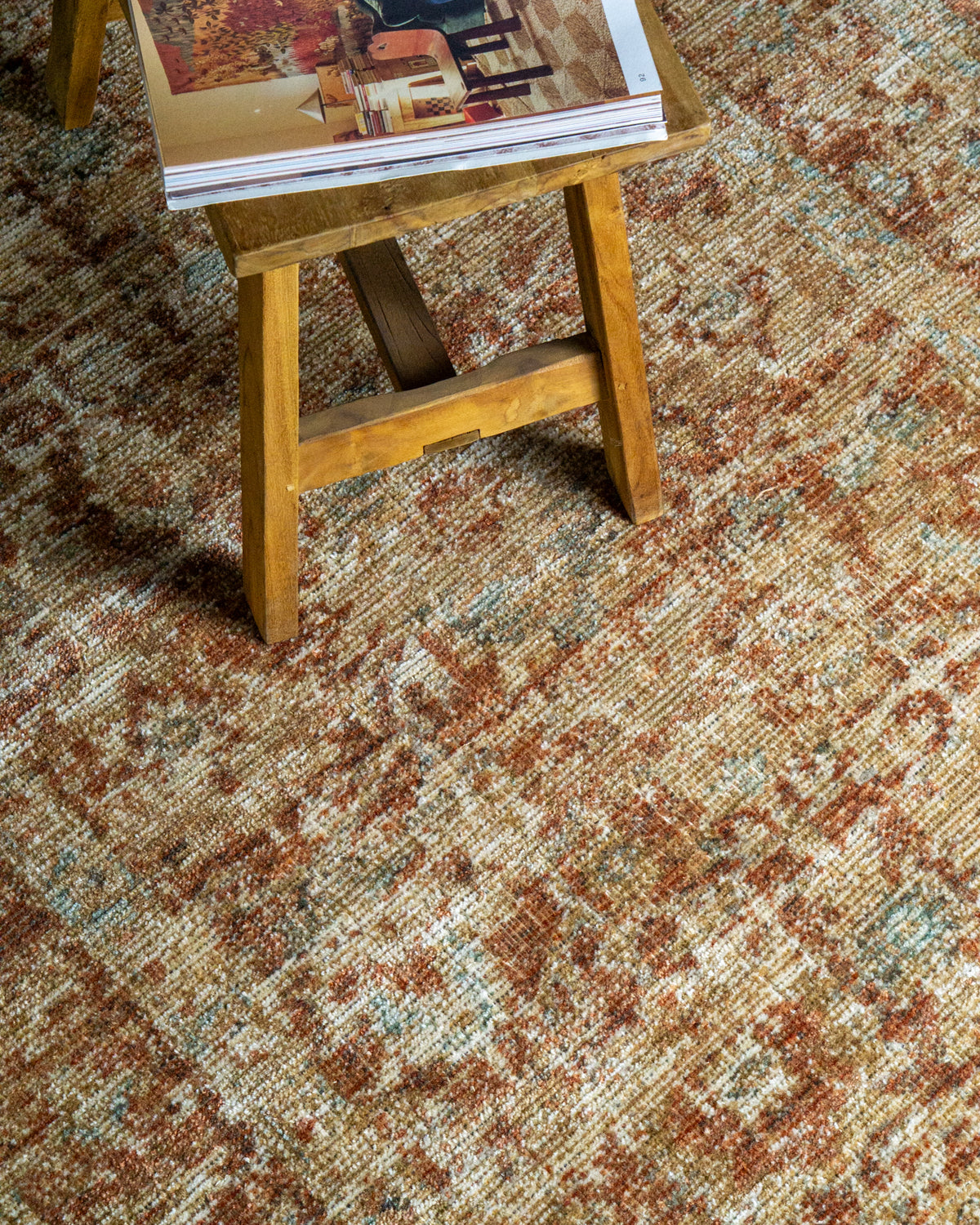 Vintage-style rug with faded terracotta and beige distressed floral pattern throughout