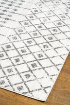 Cream and grey diamond pattern rug with tassel fringe detailing