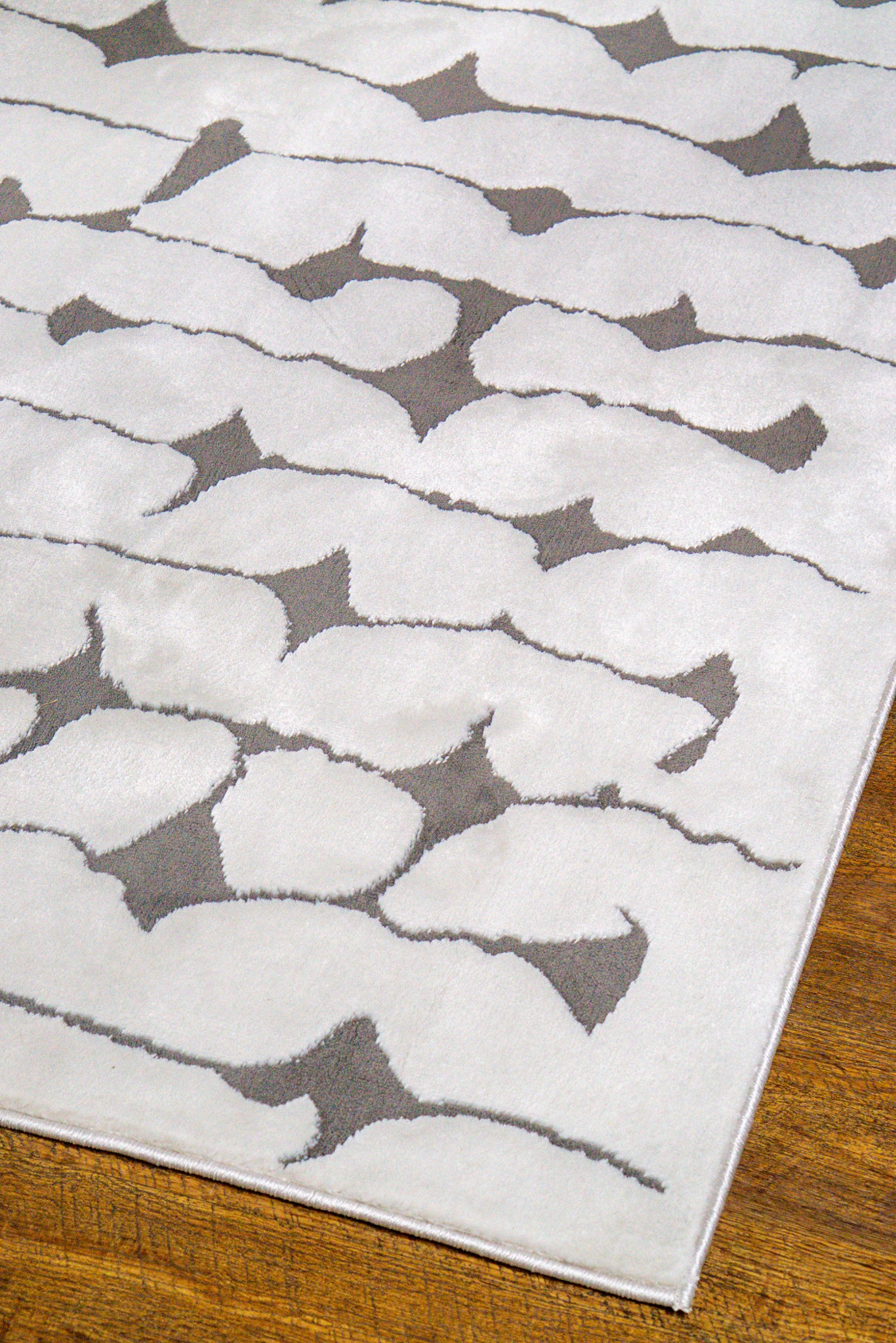Modern geometric rug with black vertical lines and diamond shapes on white