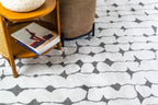 Modern geometric rug with black vertical lines and diamond shapes on white