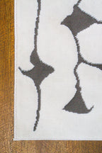 Modern geometric rug with black vertical lines and diamond shapes on white