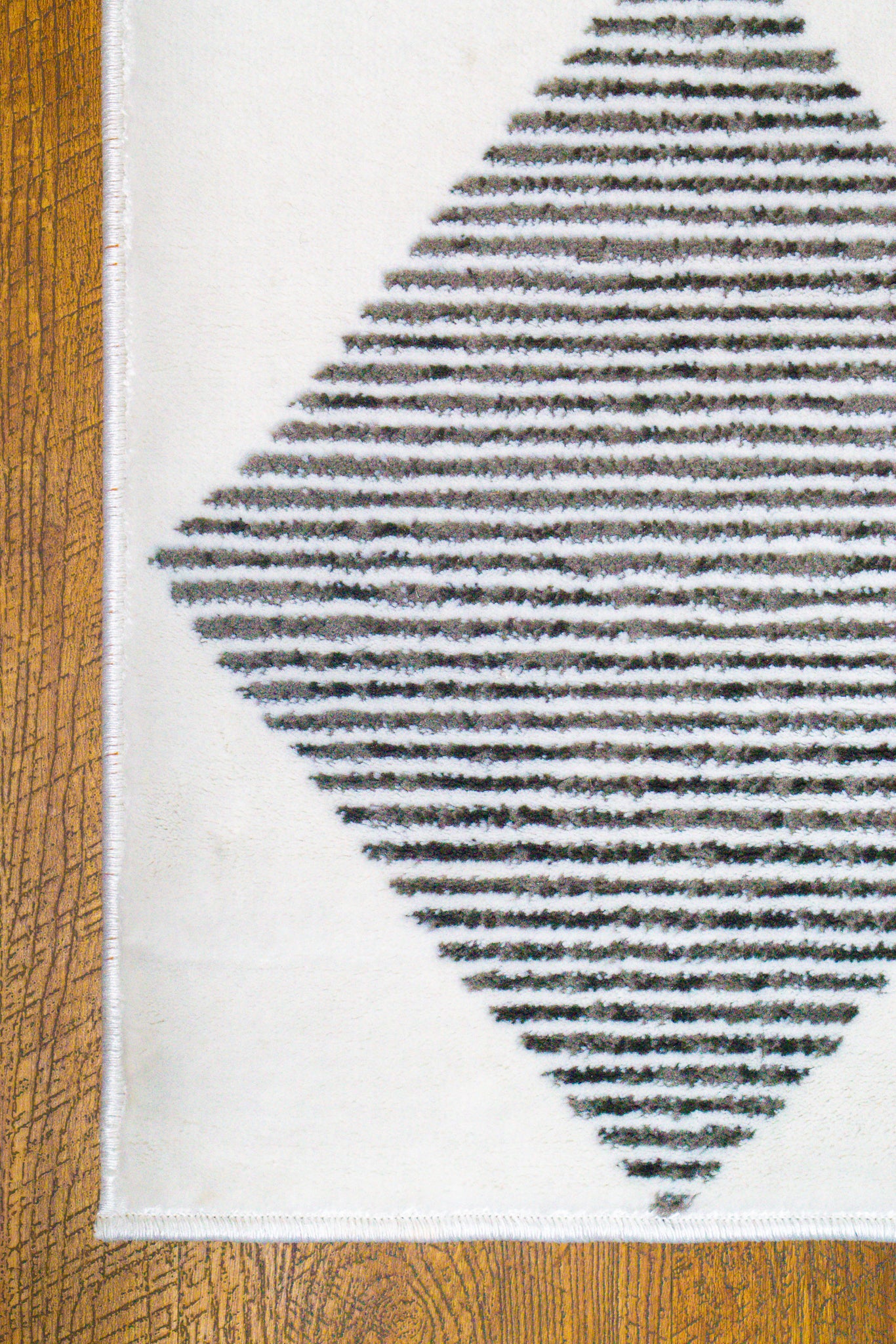 Modern geometric diamond pattern rug in black and white with textured weave