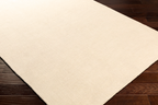 Cream colored wool rug with subtle woven texture and natural fibers