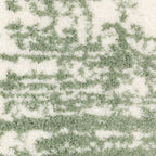 Green and white distressed textured area rug with abstract marbled pattern