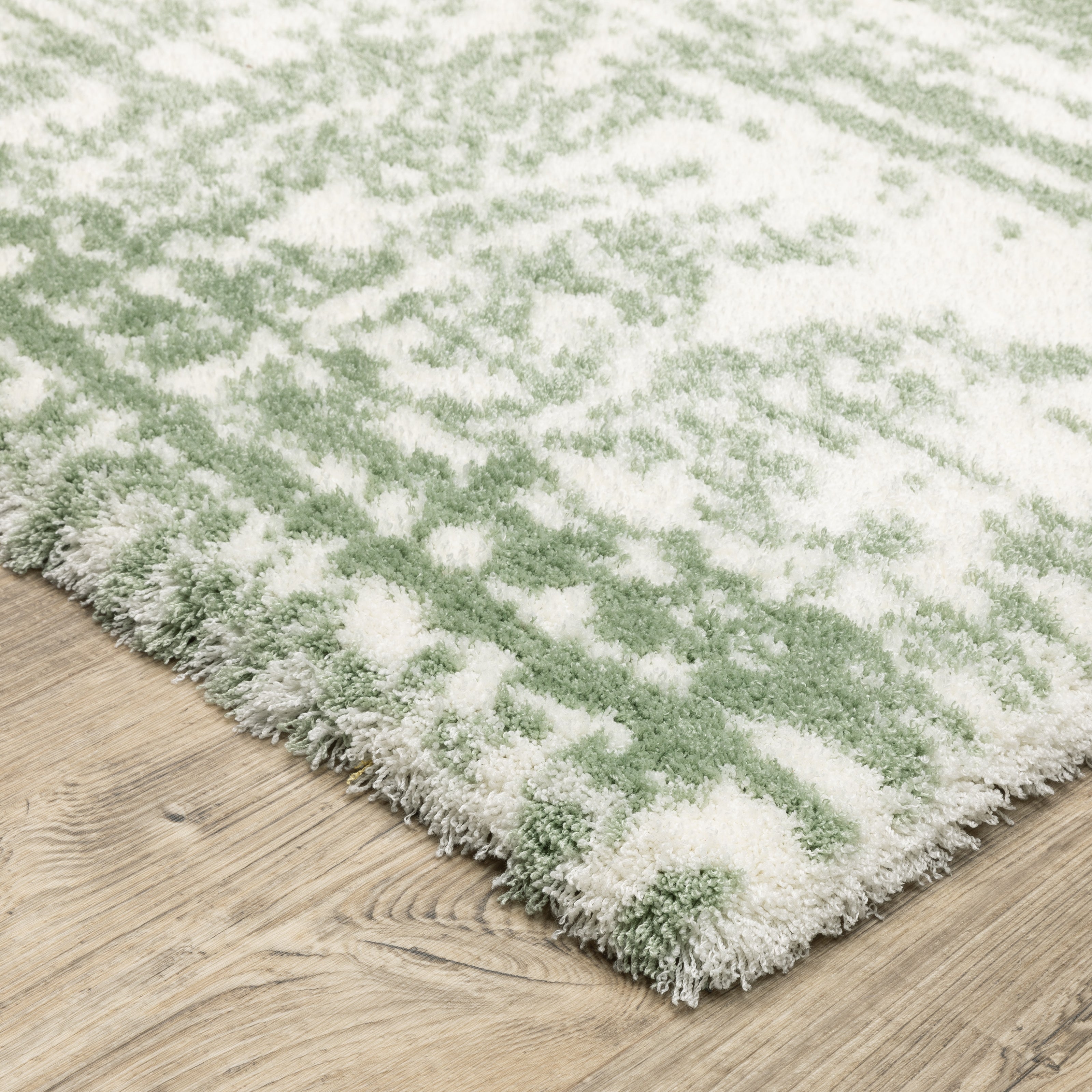 Green and white distressed textured area rug with abstract marbled pattern