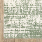 Green and white distressed textured area rug with abstract marbled pattern