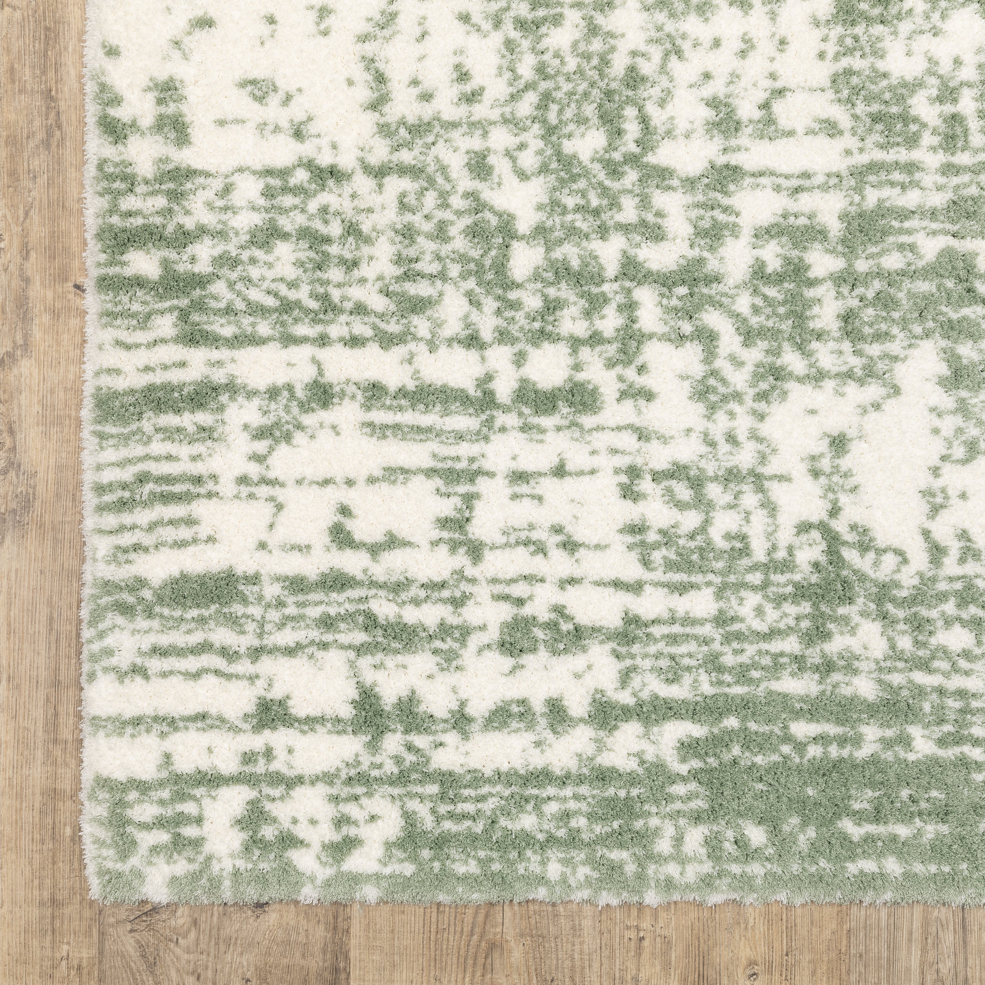 Green and white distressed textured area rug with abstract marbled pattern