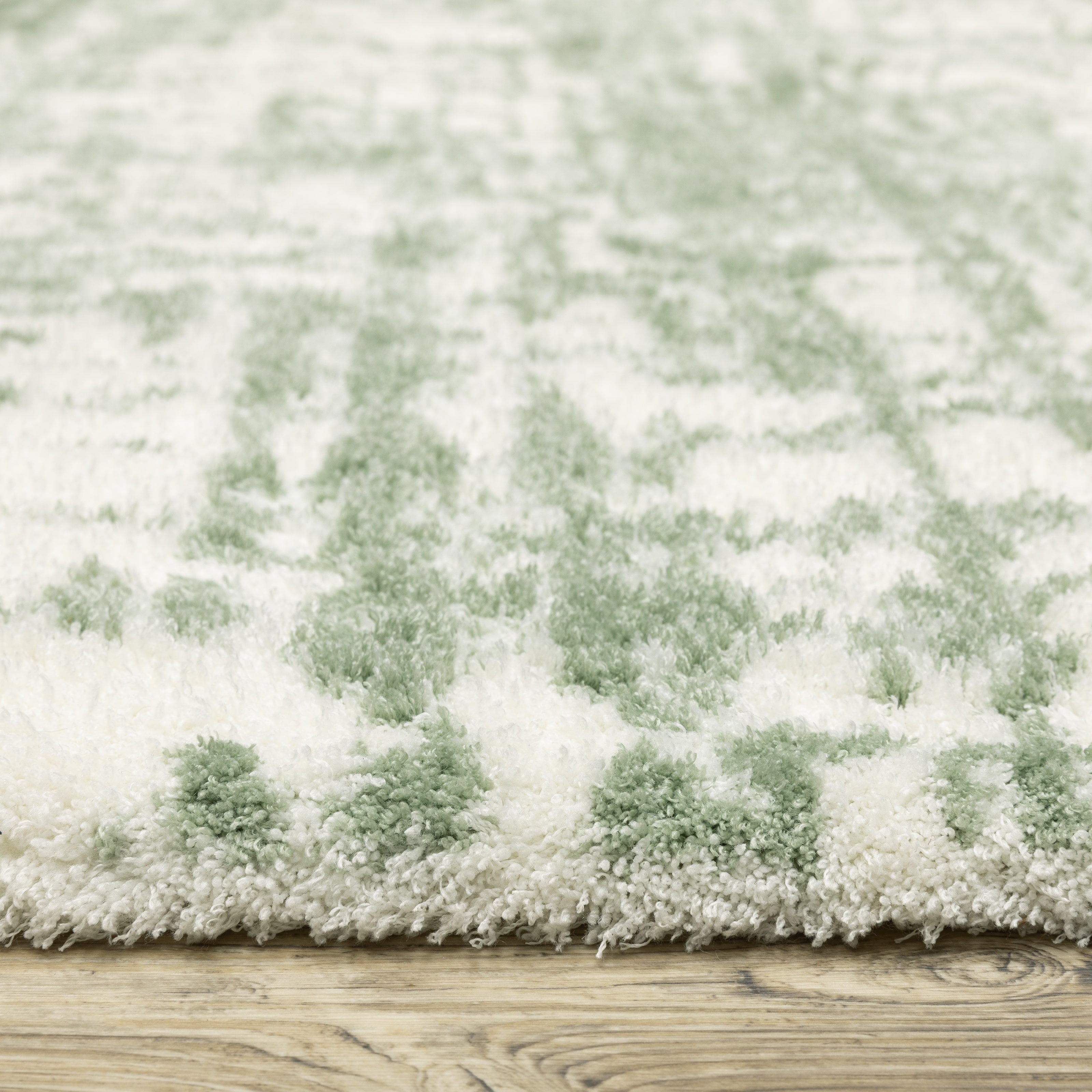 Green and white distressed textured area rug with abstract marbled pattern