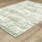 Green and white distressed textured area rug with abstract marbled pattern