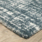 Modern teal and white textured area rug with abstract distressed pattern