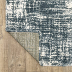 Modern teal and white textured area rug with abstract distressed pattern