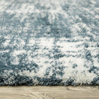 Modern teal and white textured area rug with abstract distressed pattern