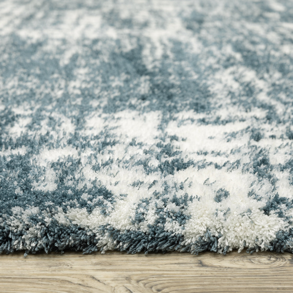 Modern teal and white textured area rug with abstract distressed pattern