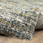 Textured striped area rug in grey, blue, green and cream tones