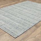 Grey woven rug with dense textured pattern and neutral tones throughout