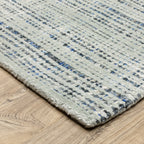 Grey woven rug with dense textured pattern and neutral tones throughout