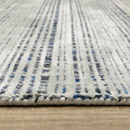 Grey woven rug with dense textured pattern and neutral tones throughout