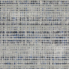Grey woven rug with dense textured pattern and neutral tones throughout