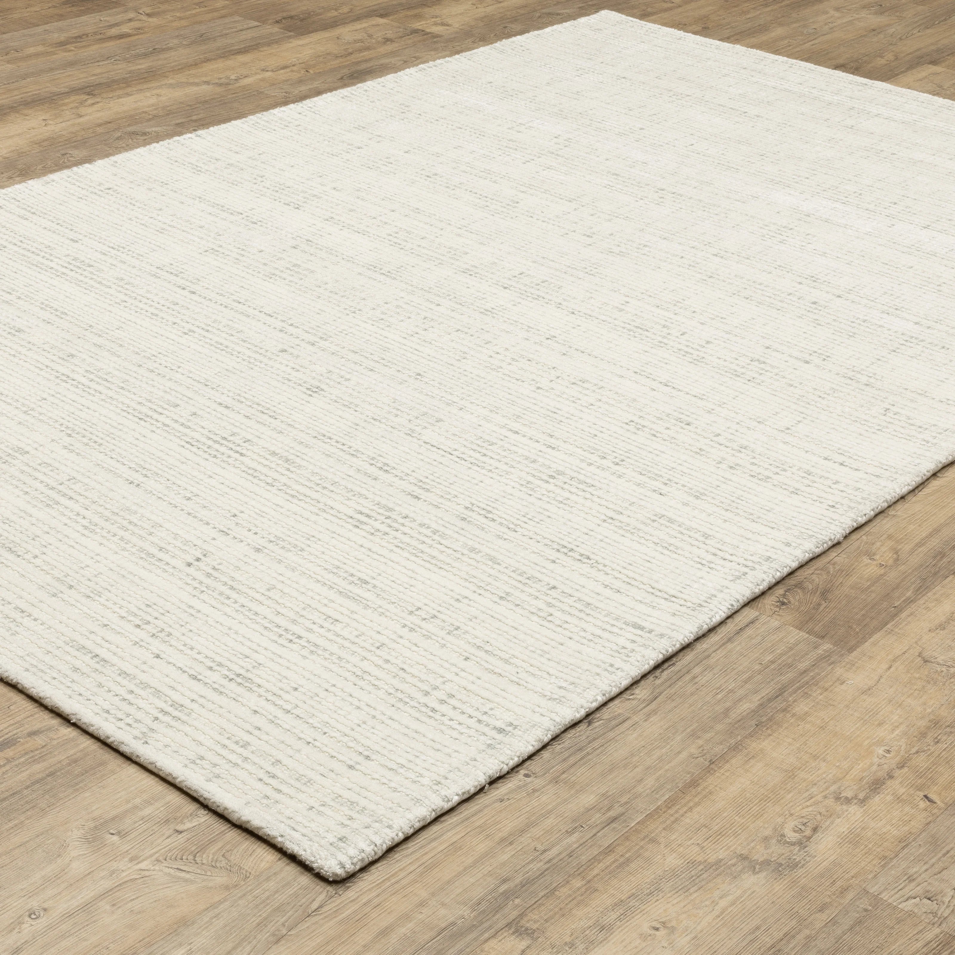 Cream textured wool rug on light wood flooring with visible weave pattern