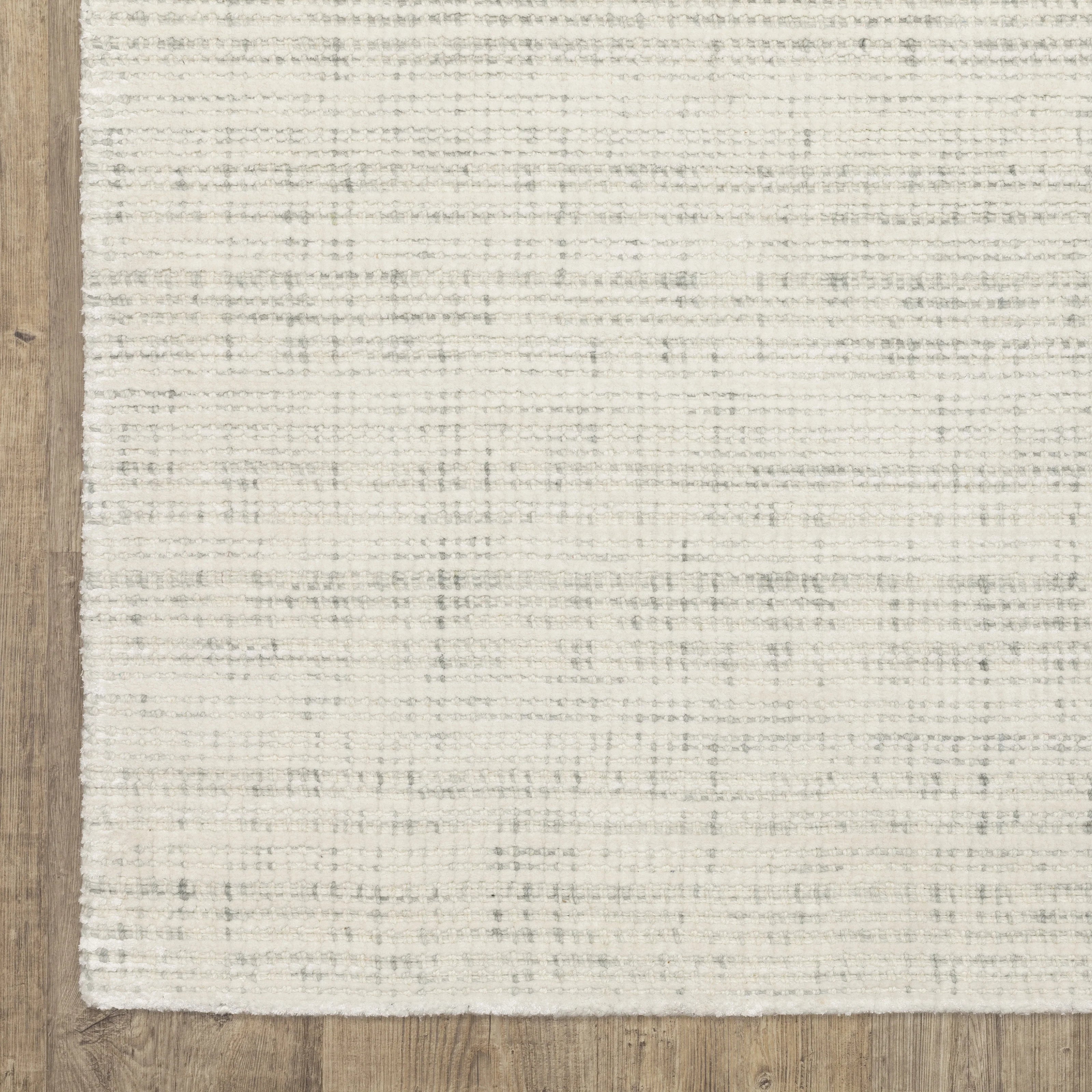 Cream textured wool rug on light wood flooring with visible weave pattern