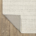 Cream textured wool rug on light wood flooring with visible weave pattern