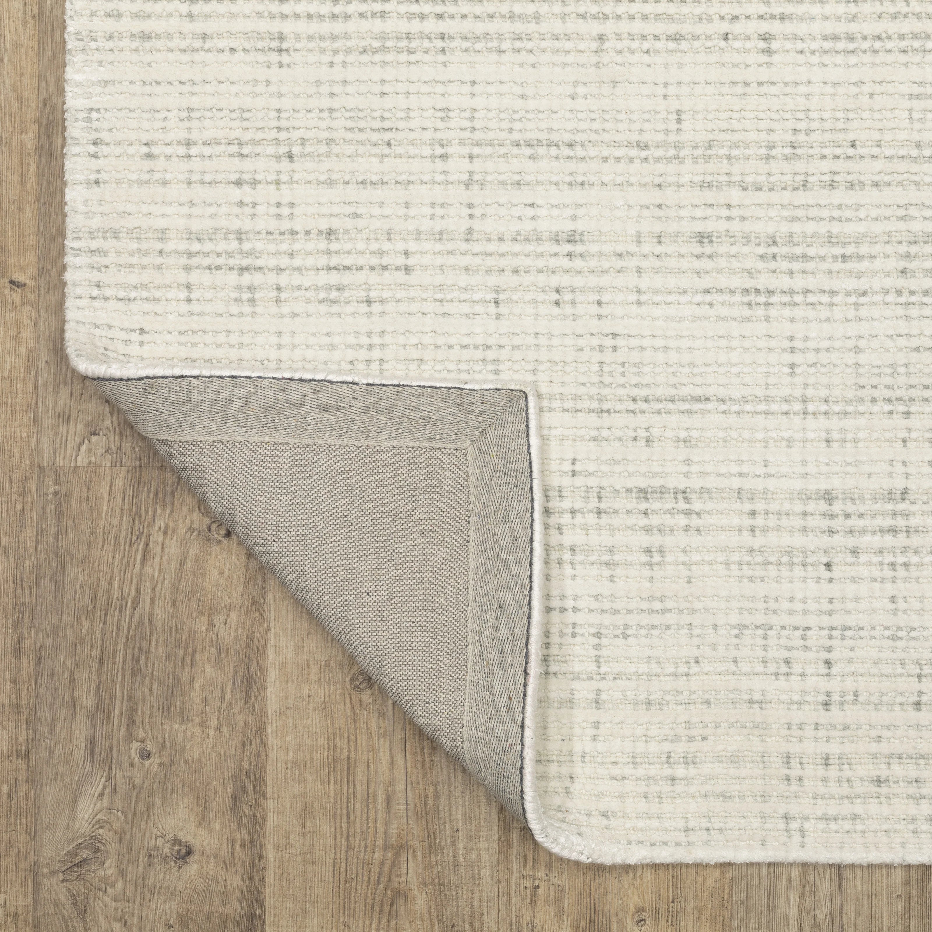 Cream textured wool rug on light wood flooring with visible weave pattern