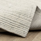 Cream textured wool rug on light wood flooring with visible weave pattern