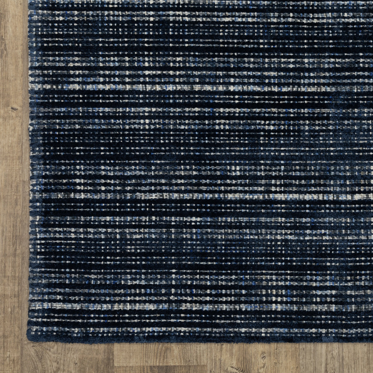Dark blue textured woven rug with horizontal stripe pattern and neutral accents