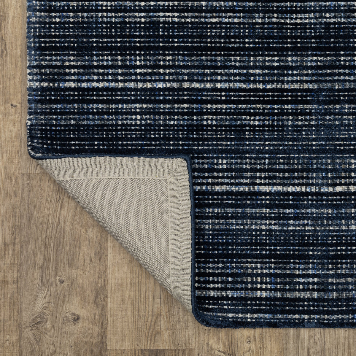 Dark blue textured woven rug with horizontal stripe pattern and neutral accents