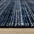 Dark blue textured woven rug with horizontal stripe pattern and neutral accents