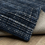 Dark blue textured woven rug with horizontal stripe pattern and neutral accents