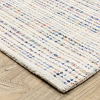 Modern cream and blue striped wool rug on light wood flooring