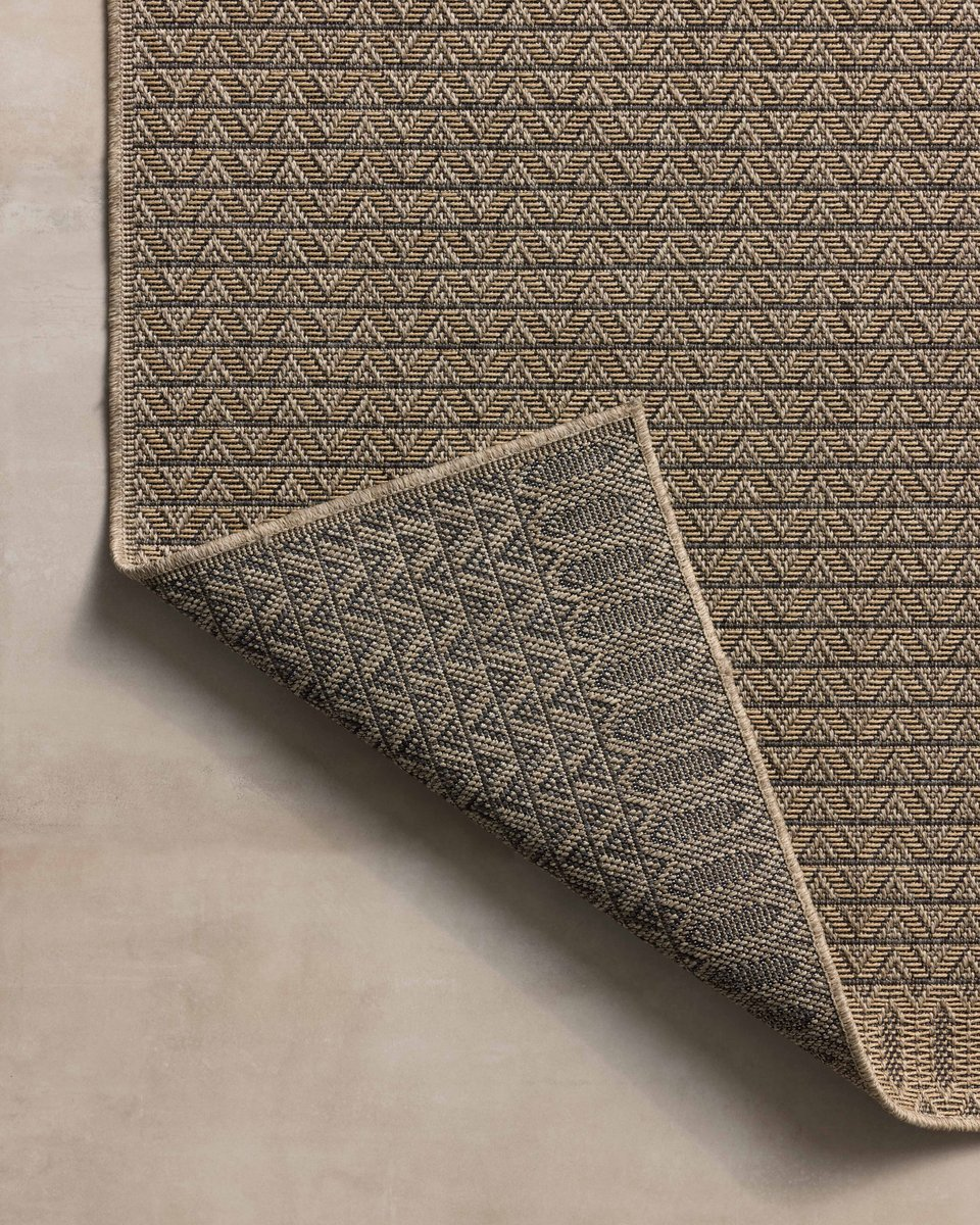 Tan and brown geometric patterned rug with textured weave and striped borders